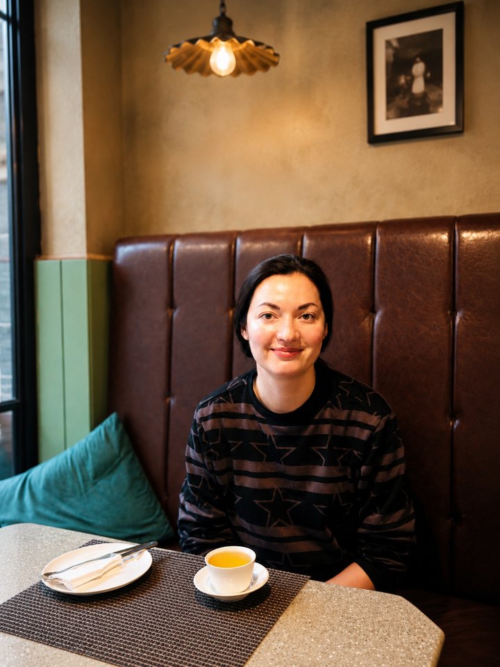 A guest with a cup of tea in a leather booth at Café Vagabond