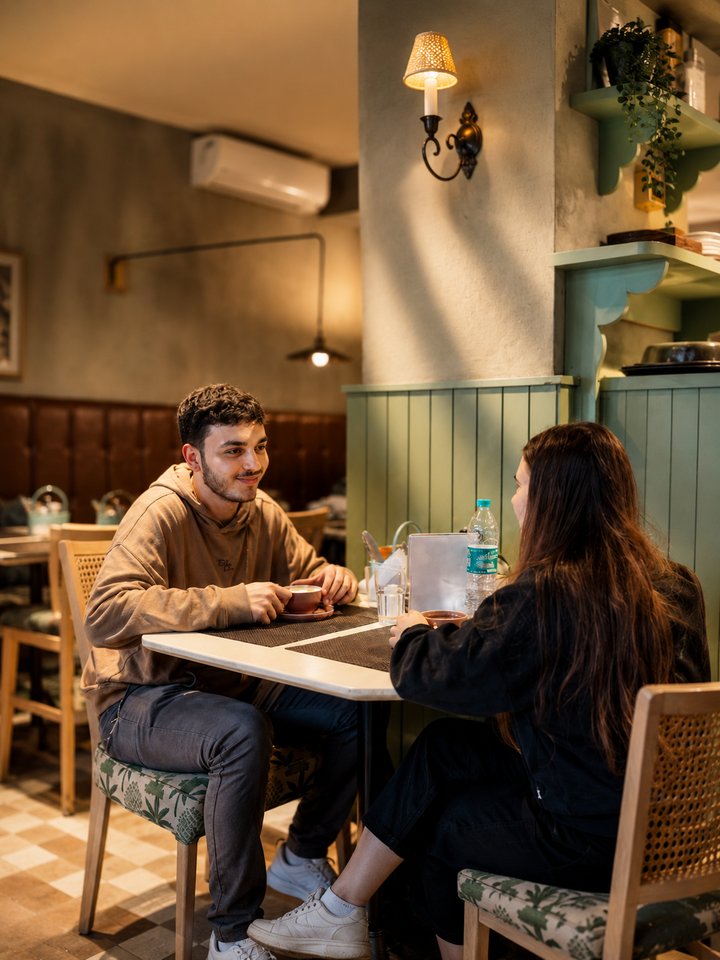 A couple in conversation over coffee at Café Vagabond